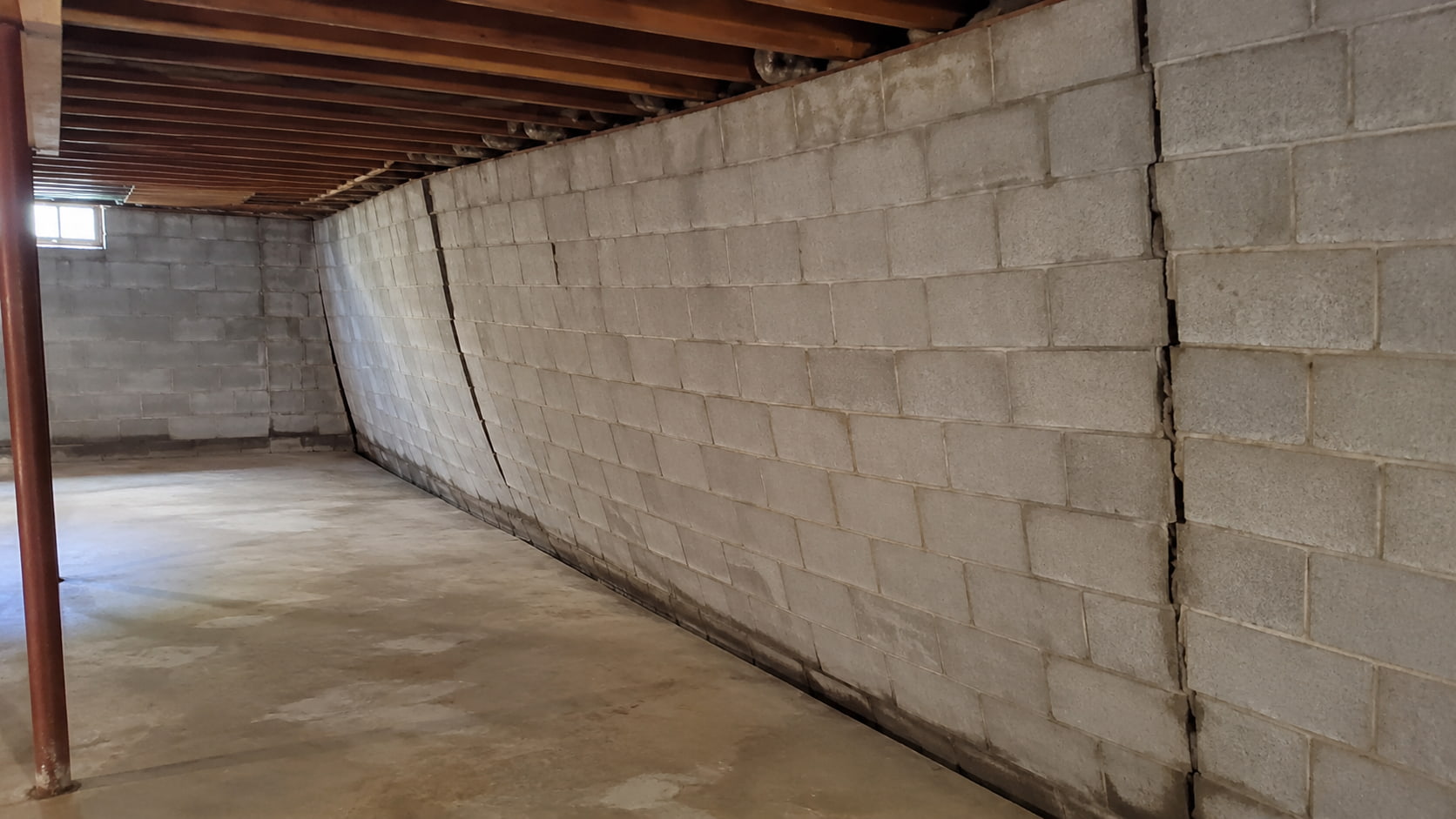 Stair-step cracks in a block foundation wall showing a warning sign of structural movement in a Southeast Michigan basement